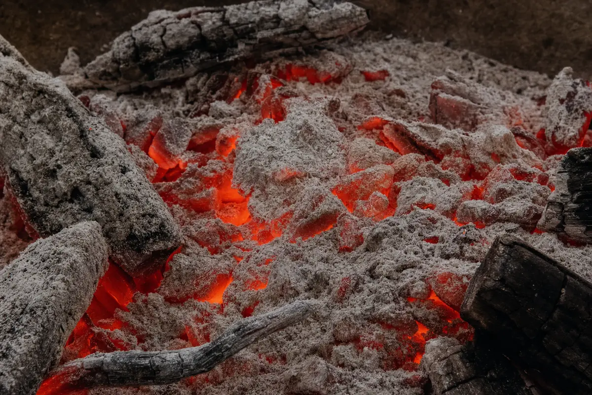 Un lit de braises rougeoyantes recouvert d’une fine cendre blanche.